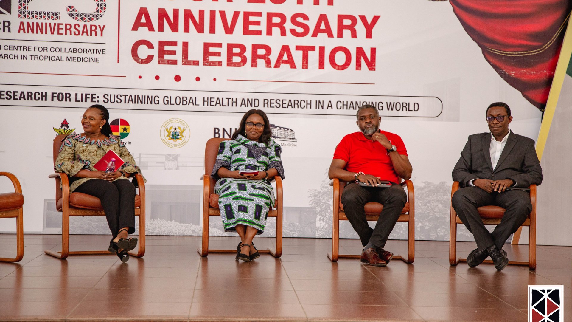 The photo shows two African female scientists and two African male scientists sitting in chairs on stage and discussing.