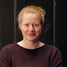 PhD Kathrin Schuldt: eine Forscherin mit blond-rötlichem Haar, dass zu einem Zopf gebunden ist und einem weinrotem Oberteil.