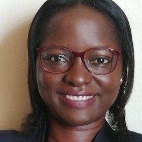 Dr. Deborah Ehichioya: eine Forscherin lächelt in die Kamera. Sie trägt schulterlanges schwarzes Haar, eine rote Brille und eine schwarzes Oberteil.