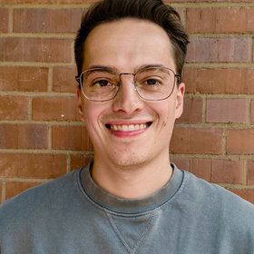 A man with glasses looking in a friendly manner towards the camera