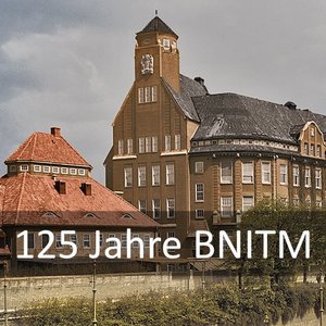 Historisches Gebäude mit markanter Architektur vor bewölktem Himmel. Schrift: „125 Jahre BNITM“.