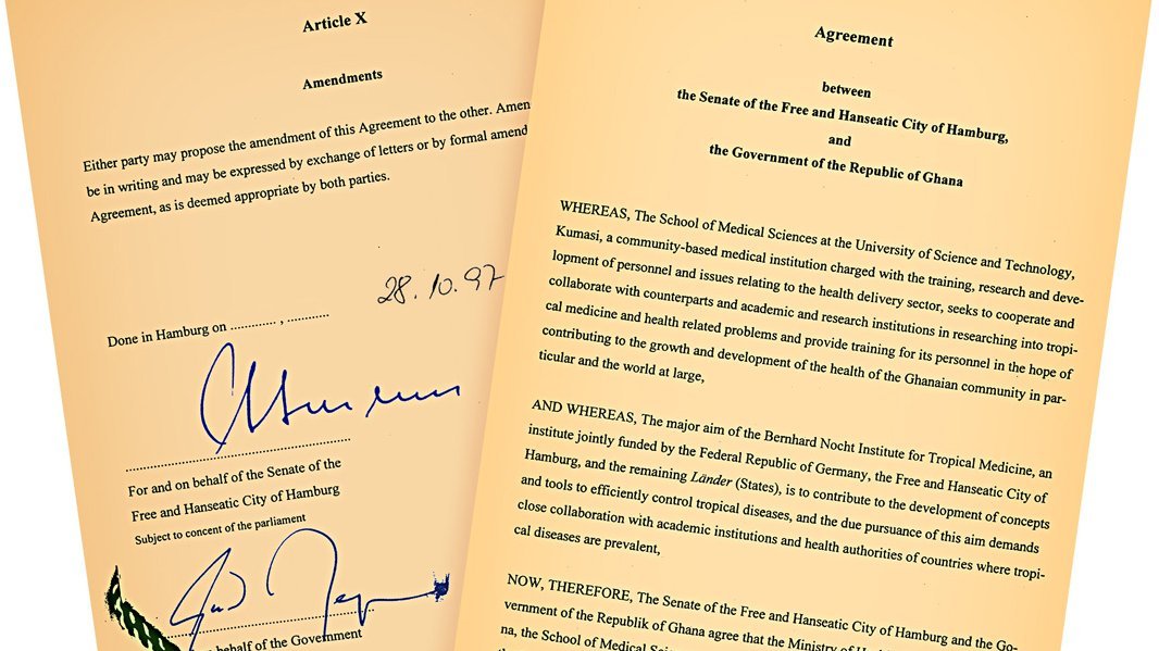 Zu sehen sind zwei Seiten des Staatsvertrags, links unten mit rotem Siegel, Datum und Unterschriften.