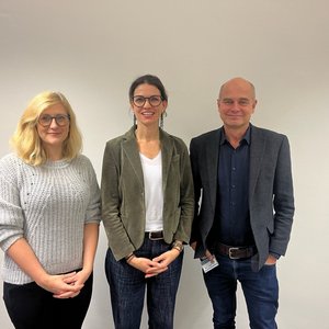 Das Foto zeigt von links nach rechts Sarah Eitze (blonde lange Haare, hellgrauer Pulli), Cornelia Betsch (dunkler Pferdeschwanz, weißes Shirt, Jeans, dunkelgrüner Blazer) und Jürgen May (Glatze, Jeans, dunkelblaues Hemd, dunkelgraues Jackett).