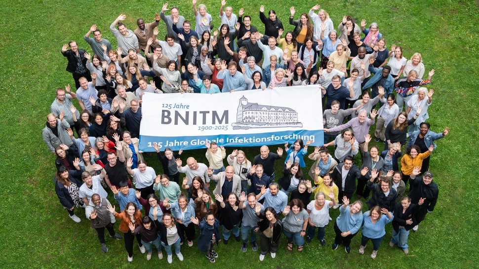 Das BNITM hat mehr als 400 Mitarbeitende Gruppenfoto mit BNITM-Mitarbeitenden im Garten