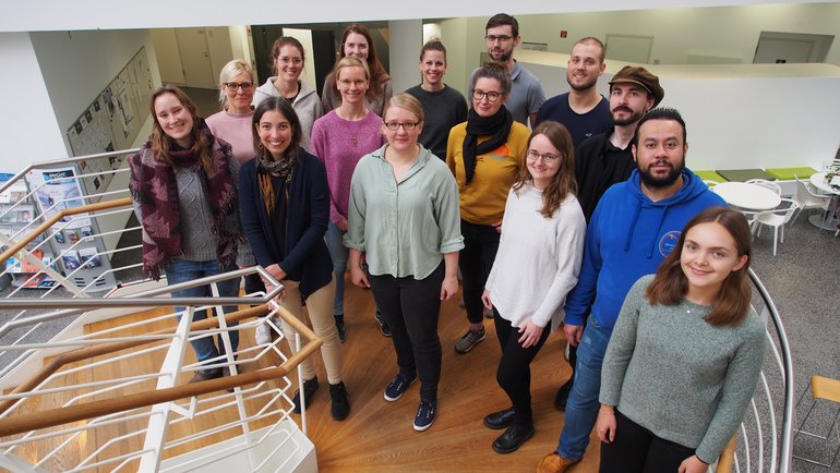 Die Mitgleider der Leibniz Junior Laborgrppe Oestereich sind hier dargestellt und stehen versammelt auf einer Treppe.