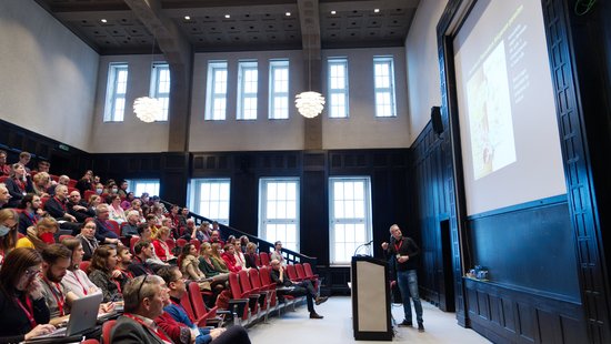 Der historische Hörsaal während ein Vortrag gehalten wird.