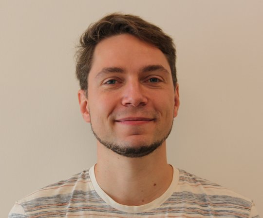 Dr. Joachim Matz Dr. Joachim Matz: ein Forscher, der in die Kamera lächelt. Er trägt ein gestreiftes Shirt, einen Bart an Kinn und Hals und kurzes braunes Haar.