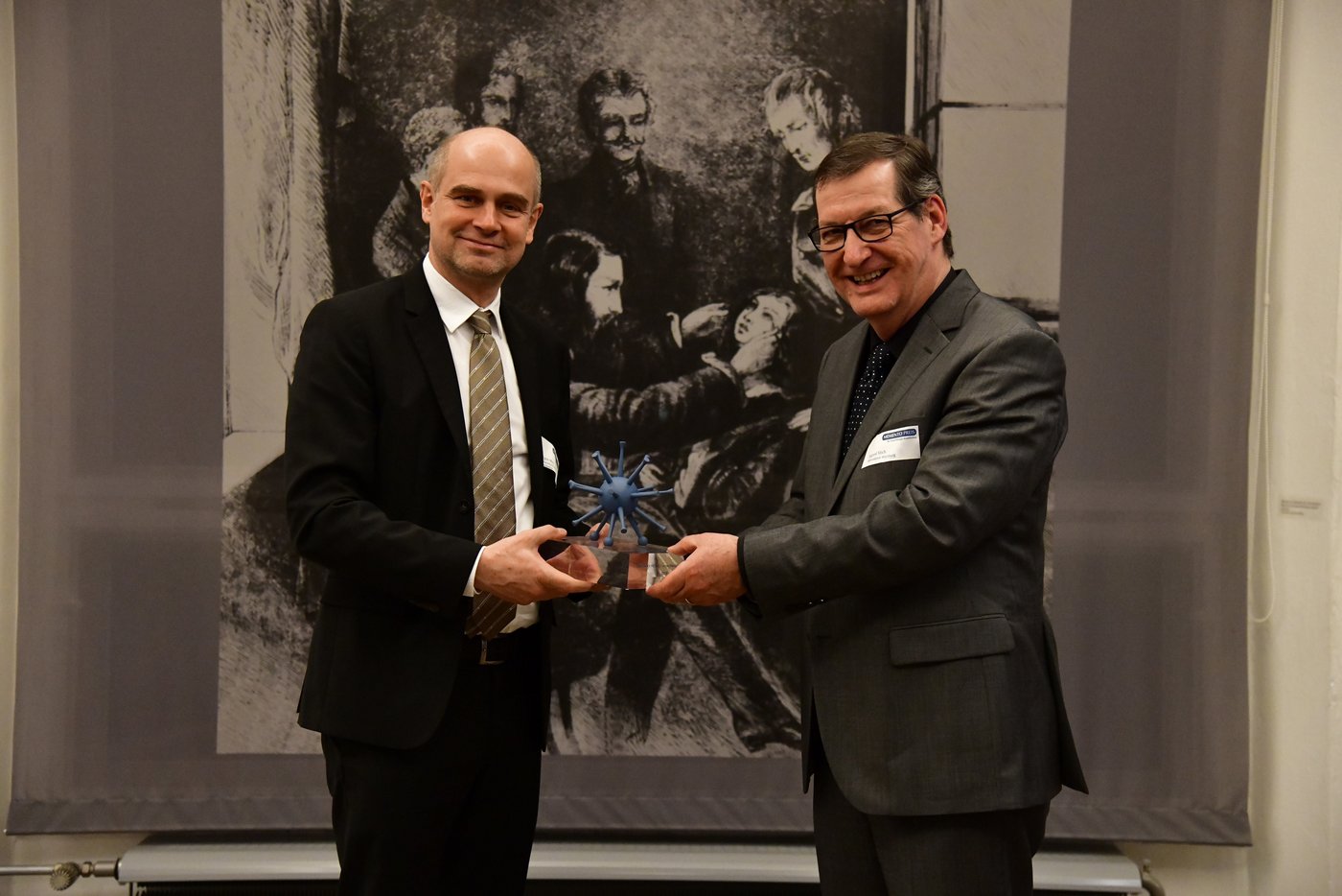 Prof. Jürgen May (links) erhält den Memento-Preis aus den Händen des Jury-Mitglieds Prof. August Stich. Quelle: BUKO / Jörg Schaaber.