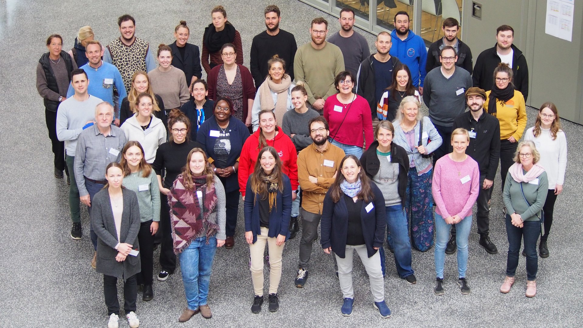 Eine Gruppe von Mitarbeitern der Abteilung Virologie hat sich im Foyer für ein Gruppenfoto versammelt.