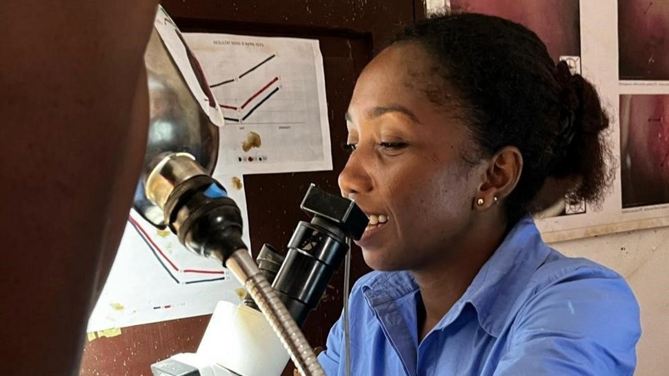 Auf dem Foto ist eine Frau in blauem Kittel zu sehen. Instrumente für eine gynäkologische Untersuchung sind zu sehen.