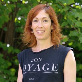 PhD Estefania Rodríguez-Burgos:a scientist with reddish, shoulder-length hair and a black T-shirt with white print.