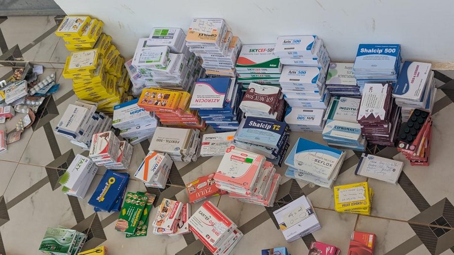 Auf dem Foto sind bunte Medikamentenpackungen auf dem Fußboden in mehreren Haufen gestapelt.