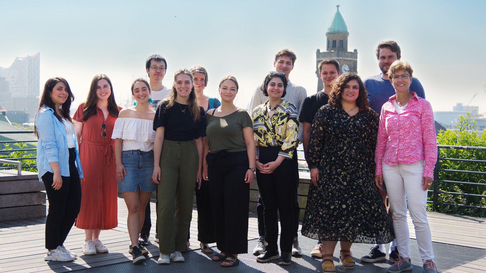 Photo of a group of diverse researchers standing outside with the Elbphilharmonie in the background