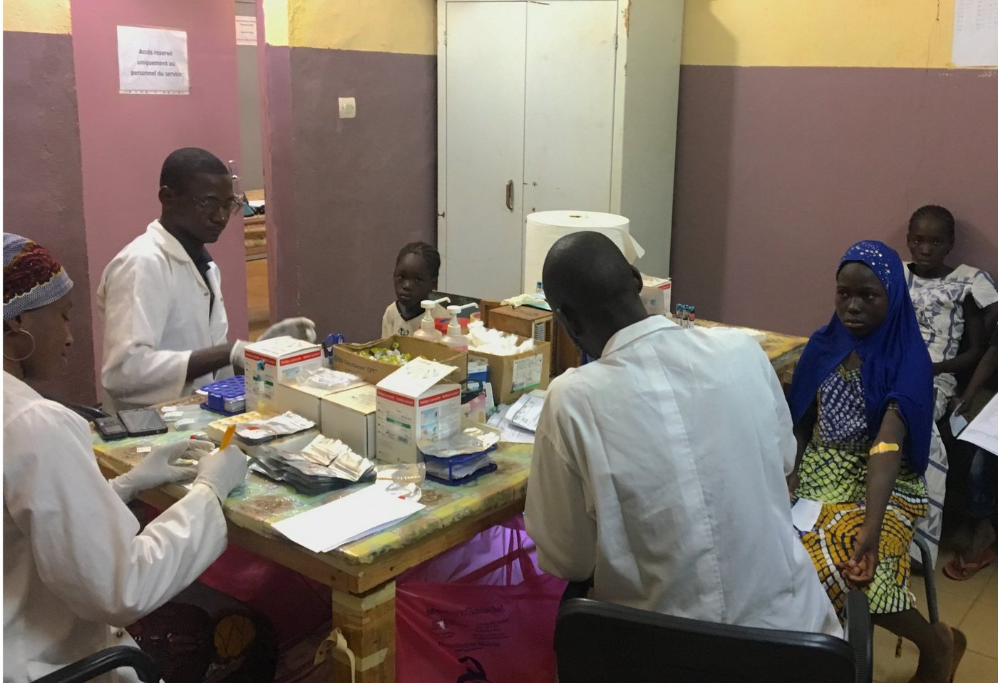 Malische Wissenschaftler führen routinemäßige klinische Verfahren während Querschnittsbesuchen in Kalifabougou, Mali, durch. Malische Wissenschaftler führen routinemäßige klinische Verfahren während Querschnittsbesuchen in Kalifabougou, Mali, durch.