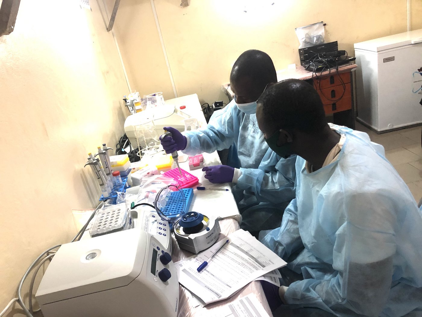 Das Bild zeigt zwei afrikanische Forschende in einer Laborsituation