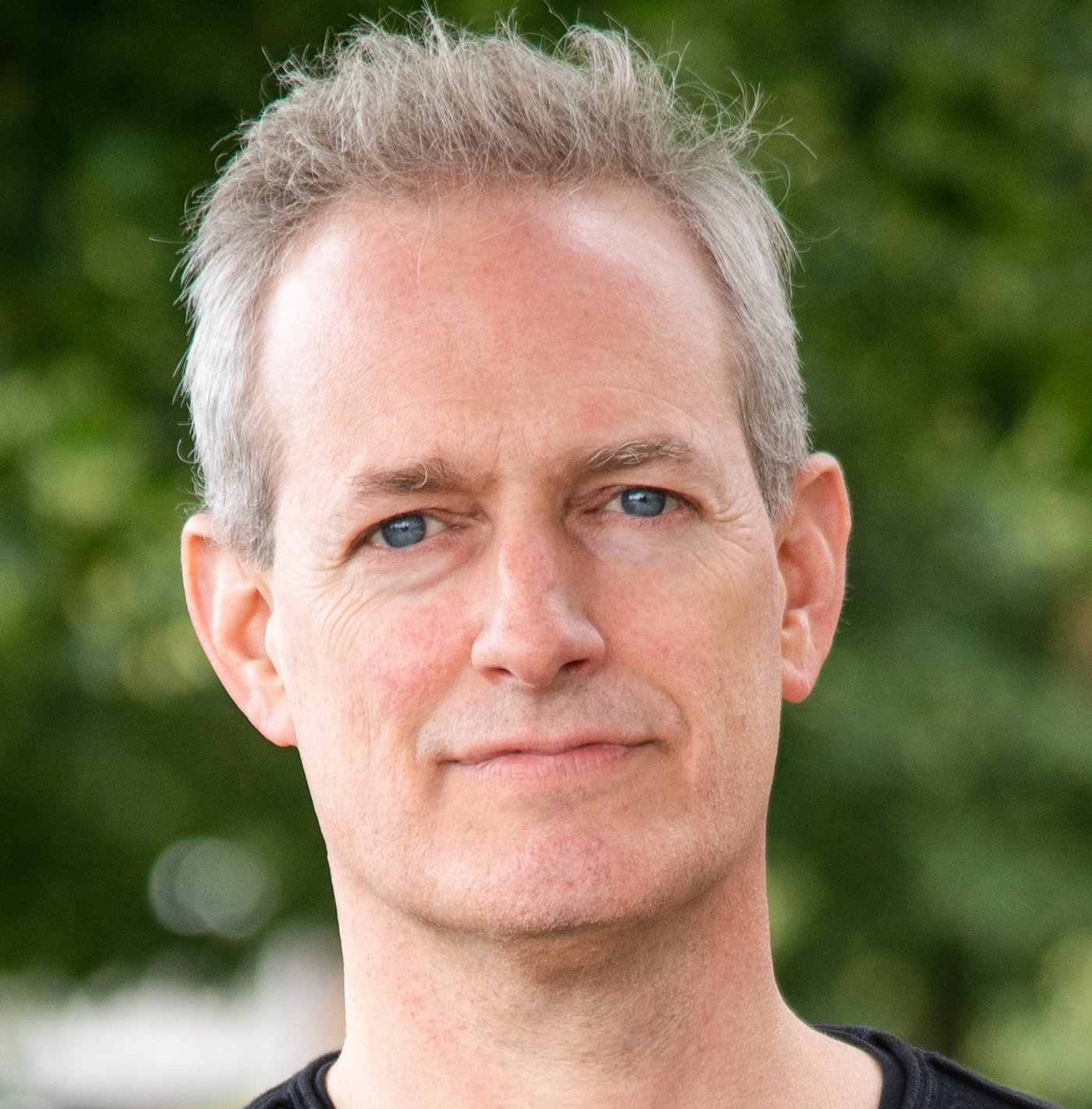 Dr. Tobias Spielmann Dr. Tobias Spielmann: ein Forscher mit kurzen, grauen Haaren und einem Dreitagebart, der ein dunkles Oberteil trägt.