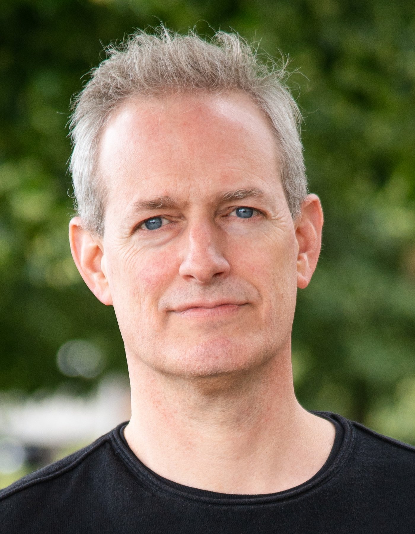 Dr. Tobias Spielmann Dr. Tobias Spielmann: ein Forscher mit kurzen, grauen Haaren und einem Dreitagebart, der ein dunkles Oberteil trägt.