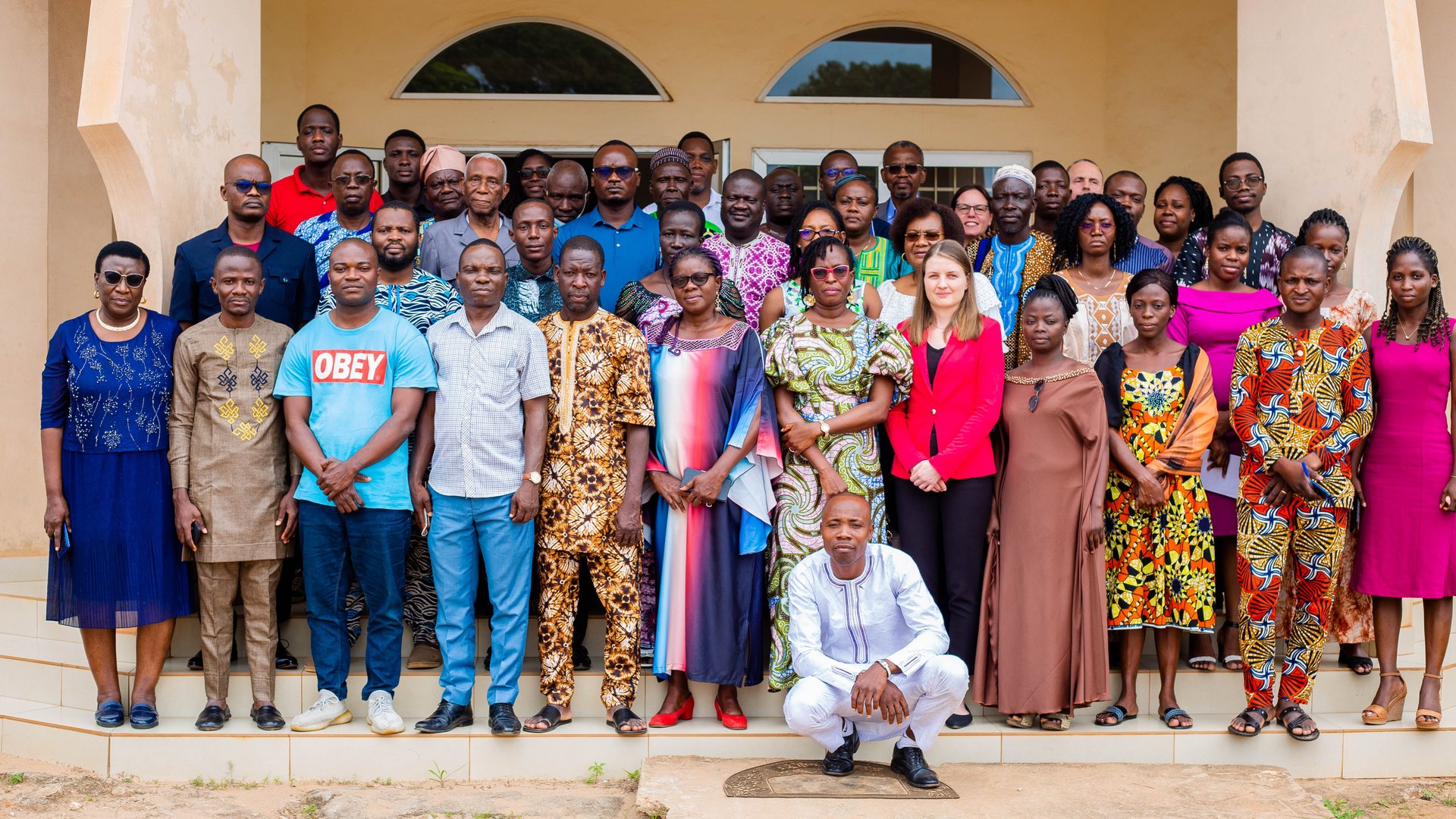 Kick-off meeting of the ASAAP trial in Benin with local authorities Gruppenbild der ASAAP-Auftaktveranstaltung in Benin: Eine große diverse Gruppe der ASAAP Auftaktsveranstaltung stehen auf einer Treppe verteilt und schauen in die Kamera. Alle tragen sommerlich-leichte Kleidung.
