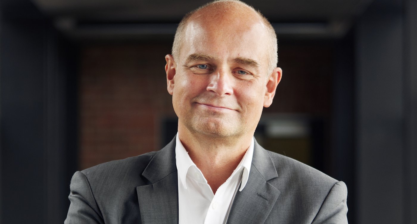 Prof. Dr Jürgen May:a researcher who is bald and wears a white shirt with a gray jacket.