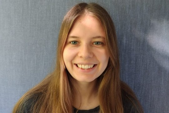 Elise Mennenga Eine junge Frau mit langen braunen Haaren schaut freundlich in die Kamera