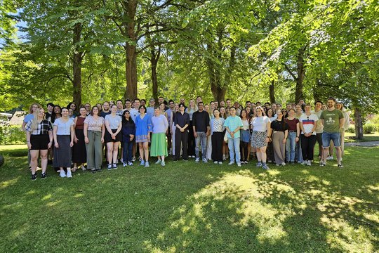 LCI summer school 2026 group picture The photo shows around 70 students standing on a lawn in front of some trees.