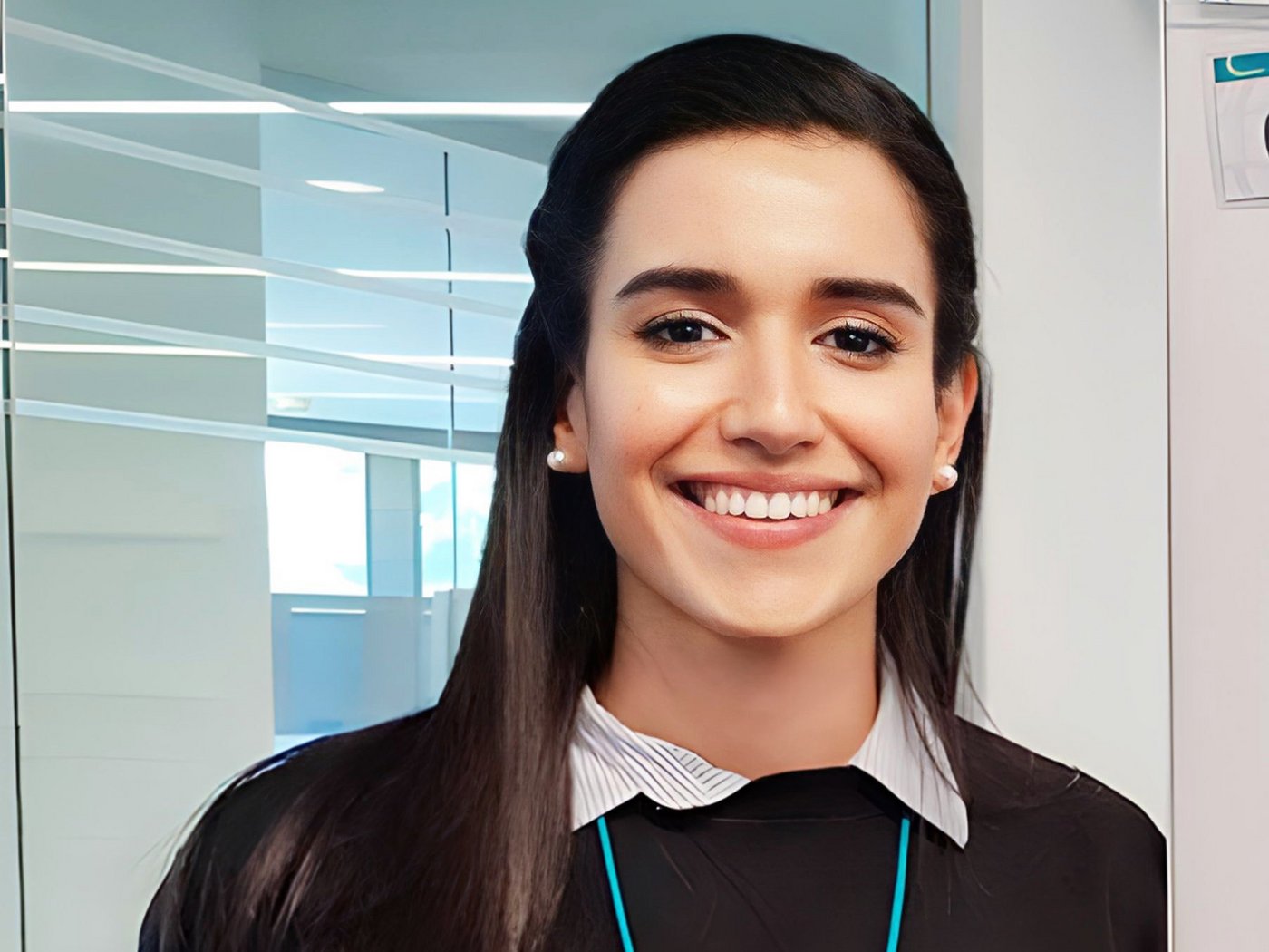 A friendly female scientist with long dark hair smiles into the camera