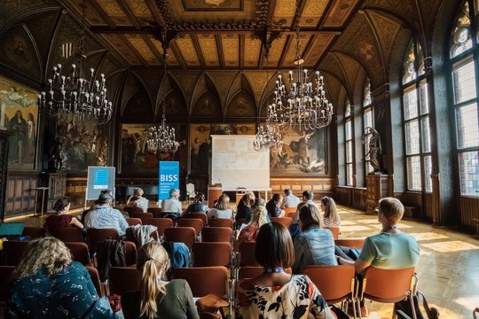 Opening Ceremony of the Behavioral Insights Summer School (BISS) 2018 A group of people sitting in chairs in an ornate room.