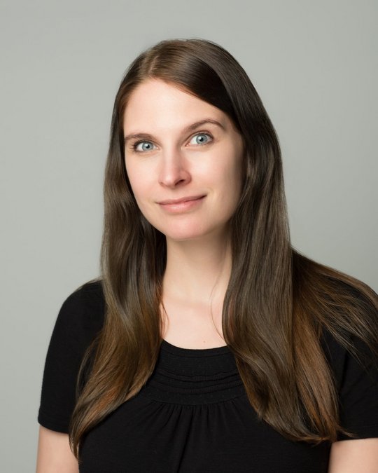 Dr. Kristina Meier Dr. Kristina Meier: Die Nachwuchswissenschaftlerin trägt lange braune Haare, ein schwarzes T-Shirt und blickt freundlich lächelnd in die Kamera.