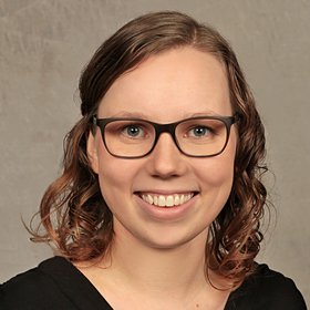 Sara Dörken:eine Forscherin, die eine schwarze Brille mit Rand, schulterlanges aschblondes Haar und eine schwarzes Oberteil trägt.