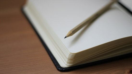 Bild von einem aufgeschlagenen Notizbuch mit Stift