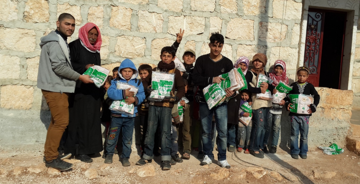 Das Bild zeigt eine syrische Familie vor einer Häuserwand.