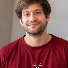 The person shows a man in his early 30s. He has dark blonde hair.