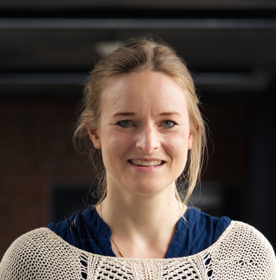 Dr. Christine Hopp Dr. Christine Hopp: eine Forscherin mit blondem zurückgebundenen Haar, dunkelblauer Bluse und weiß-beigem Netzpullover.