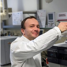 Konrad Langbecker Konrad Langbecker, a student assistant with short blond hair, is shown wearing a lab coat, while operating the GC-MS and looking directly at the camera.