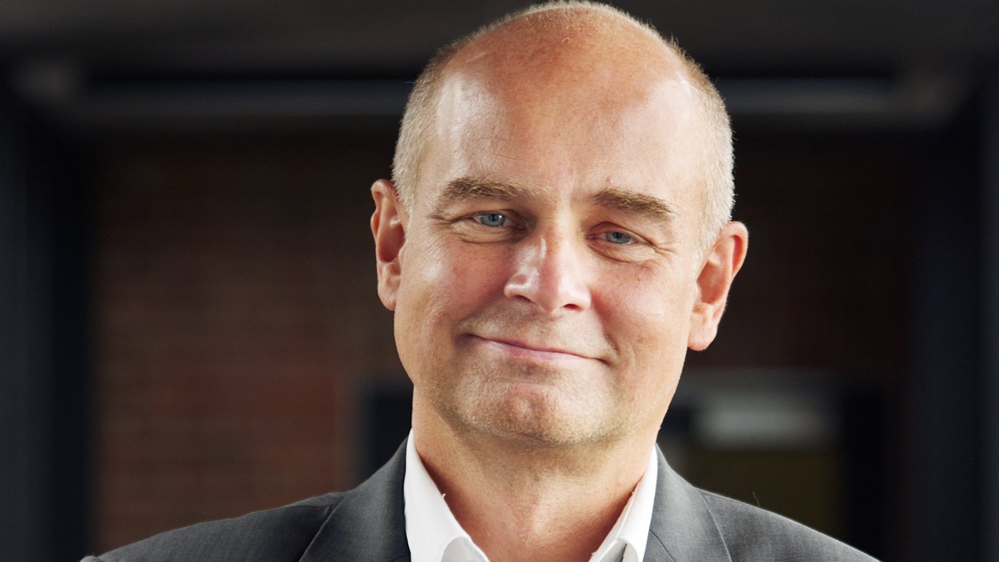 Prof. Dr Jürgen May: a researcher who is bald and wears a white shirt with a grey jacket.