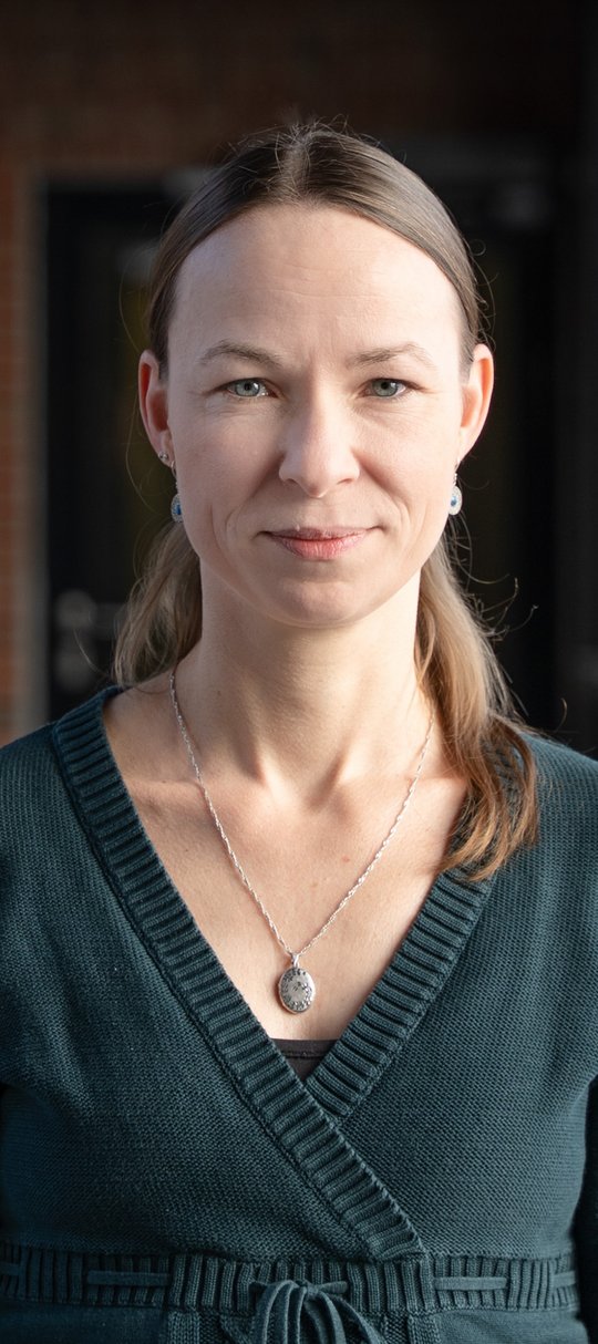 Prof. Dr. Maria Rosenthal Dr. Maria Rosenthal: eine Forscherin, die lange Haaren trägt und eine Bluse. Das Bild ist schwarz-weiß.