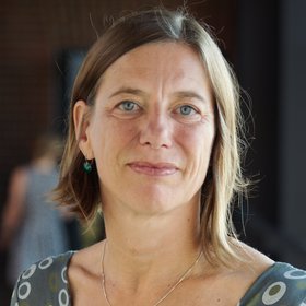 Prof. Dr Minka Breloer: a researcher, with chin-length hair. She is wearing a patterned blouse.