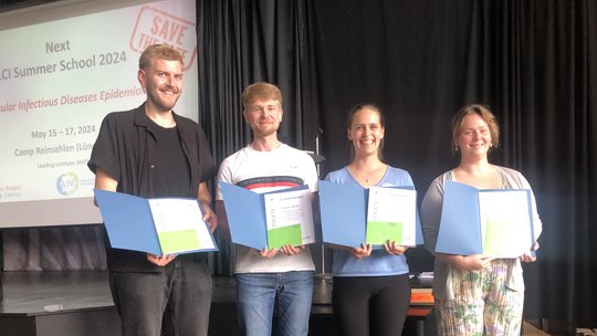 Das Foto zeigt zwei junge Männer und zwei junge Frauen mit Urkunden in der Hand.