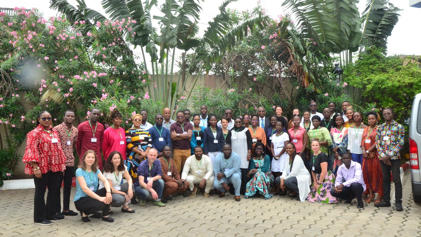 All members of the annual ASAAP study meeting in Benin standing in front of trees with flowers