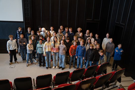 Eine Gruppe von ca. 40 Schüler:innen steht im historischen Hörsaal des BNITM.