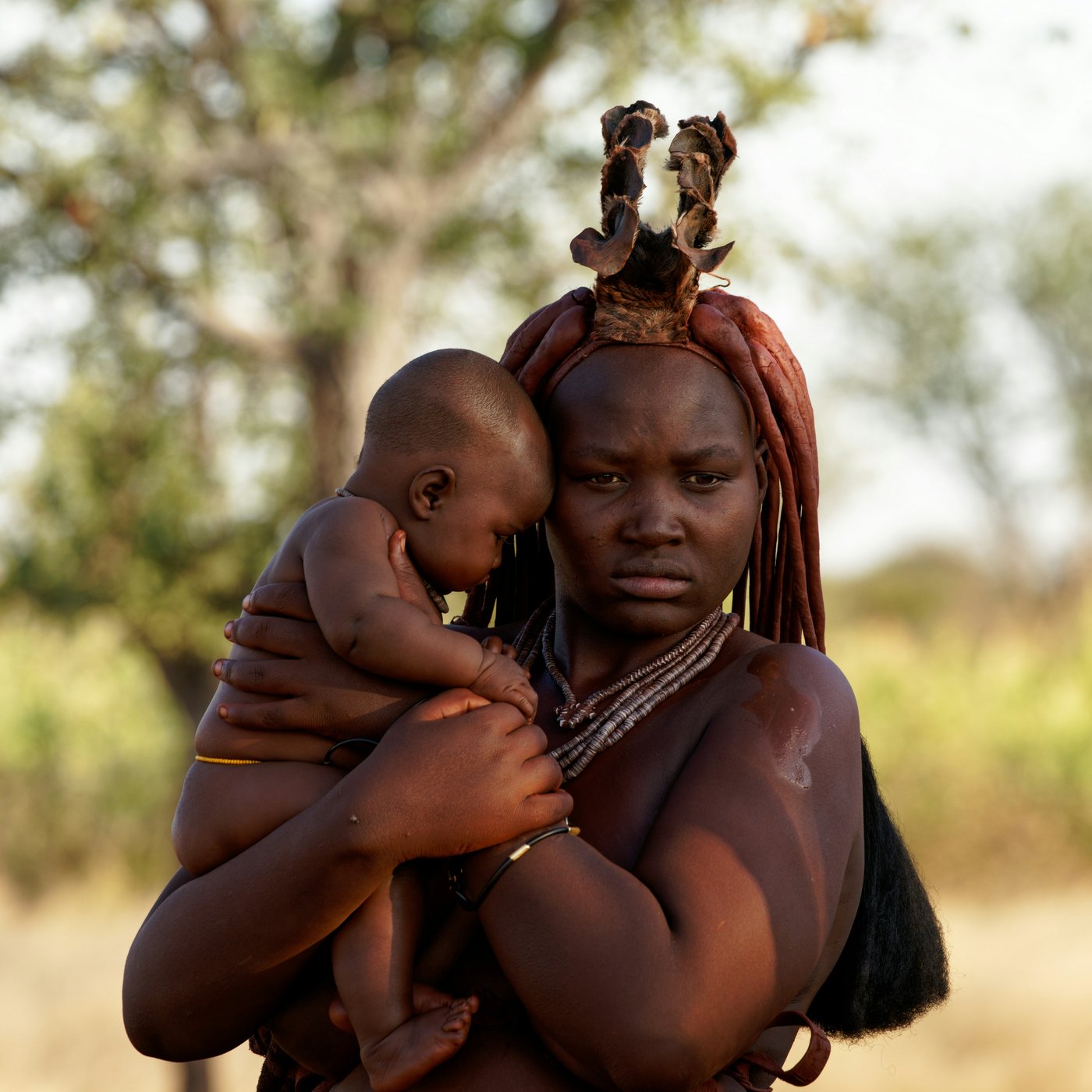 Mother and her baby in Namibia A mother holds her baby. The setting is a rural area in Namibia.