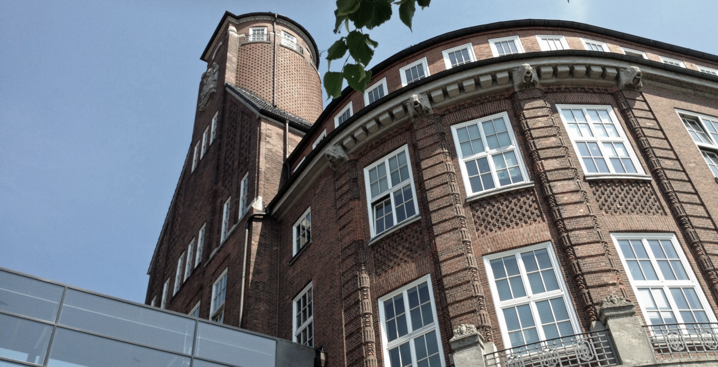 Ein Backsteingebäude mit weißen Fenstern vor blauem Himmel