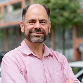 Prof. Dr. Thomas Otto: ein freundlich blickender erfahrener Forscher mit Bart und rosa Hemd