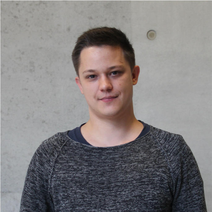 Portrait photo of the doctoral student Johannes Allweier in front of a grey concrete wall in the new building of the BNITM.