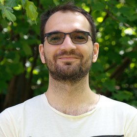 PhD Maksym Kitsera: ein Forscher, der mit Sonnenbrille in Richtung Bildbetrachter schaut. Er trägt kurzes dunkles Haar und einen kurzen Bart.