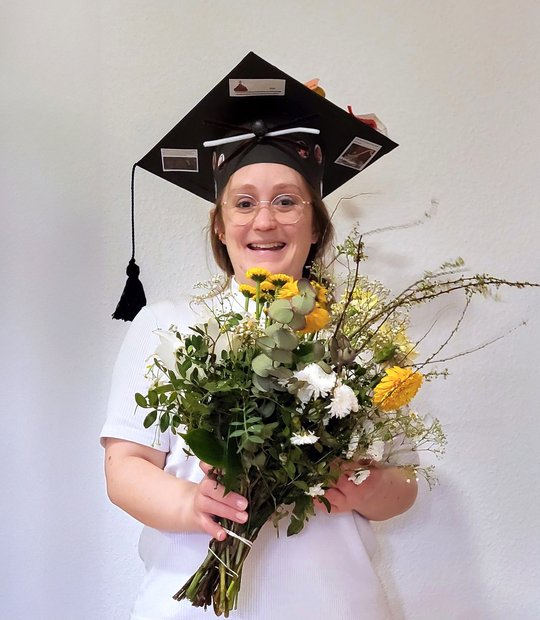The picture shows Annika Bea after her disputation with a bouquet of flowers. She is also wearing a doctor's hat