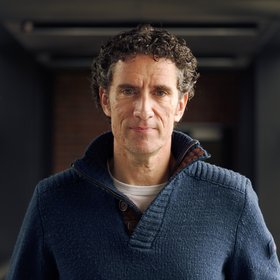 Prof. César Muñoz-Fontela: A researcher with short curls wearing a blue wool sweater.