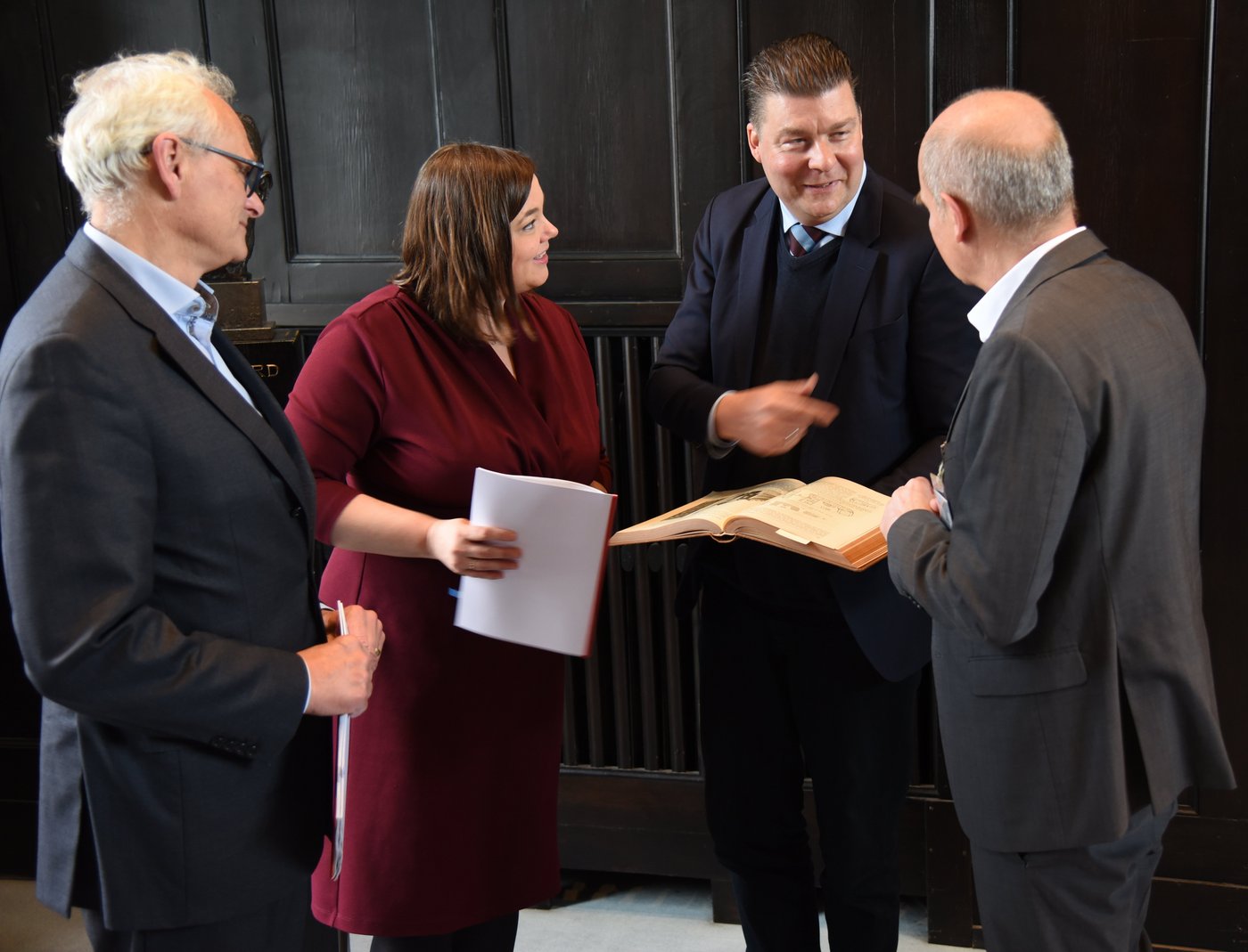 Nach der Unterzeichnung des Letter of Intent Das Bild zeigt v.l.n.r. Martin Görge, Katharina Fegebank, Andreas Dressel und Jürgen May. Sie beugen sich über ein historisches Buch über das BNITM von 1914.