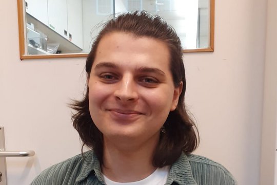 Ein netter junger Mann schaut freundlich in die Kamera