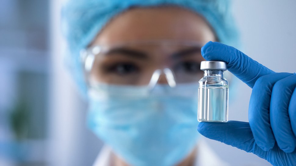 SCIENCE: Communication from the US Centers for Disease Control and Prevention (CDC) undermines trust in vaccinations A photo of a person wearing a face mask and blue laboratory gloves, holding a vial of vaccine